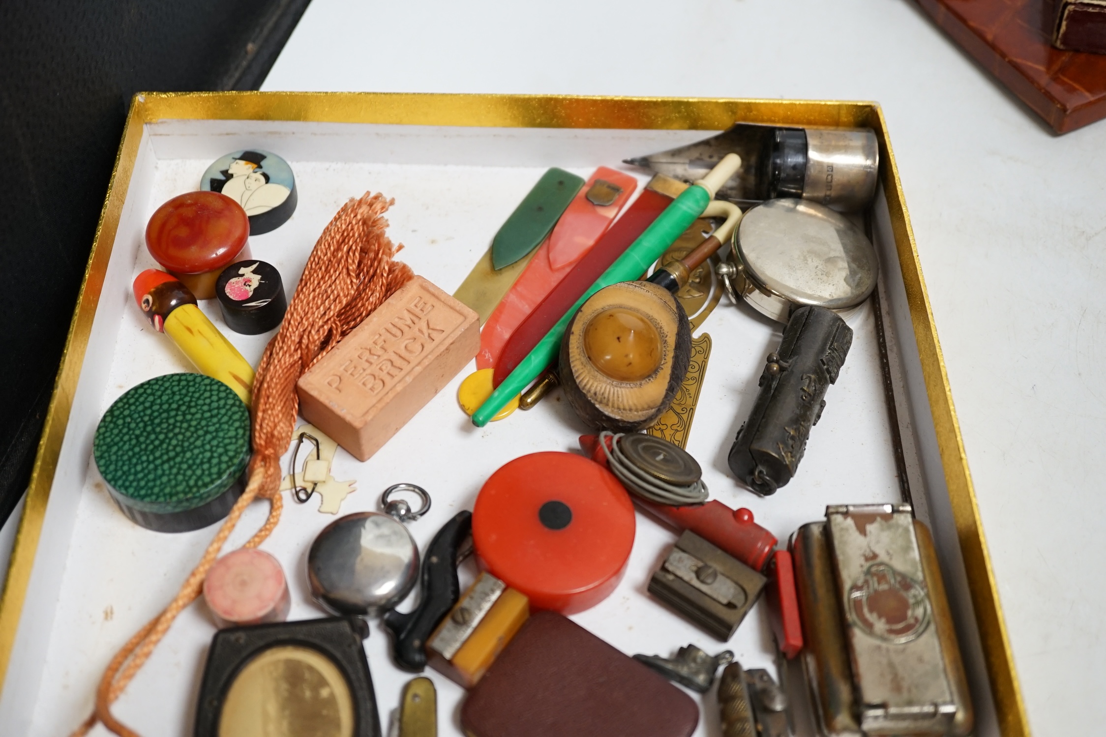 A group of mixed collectables and objects to include Bakelite boxes, pen knives, white metal charms and a gilt metal compact, etc. Condition - varies, fair